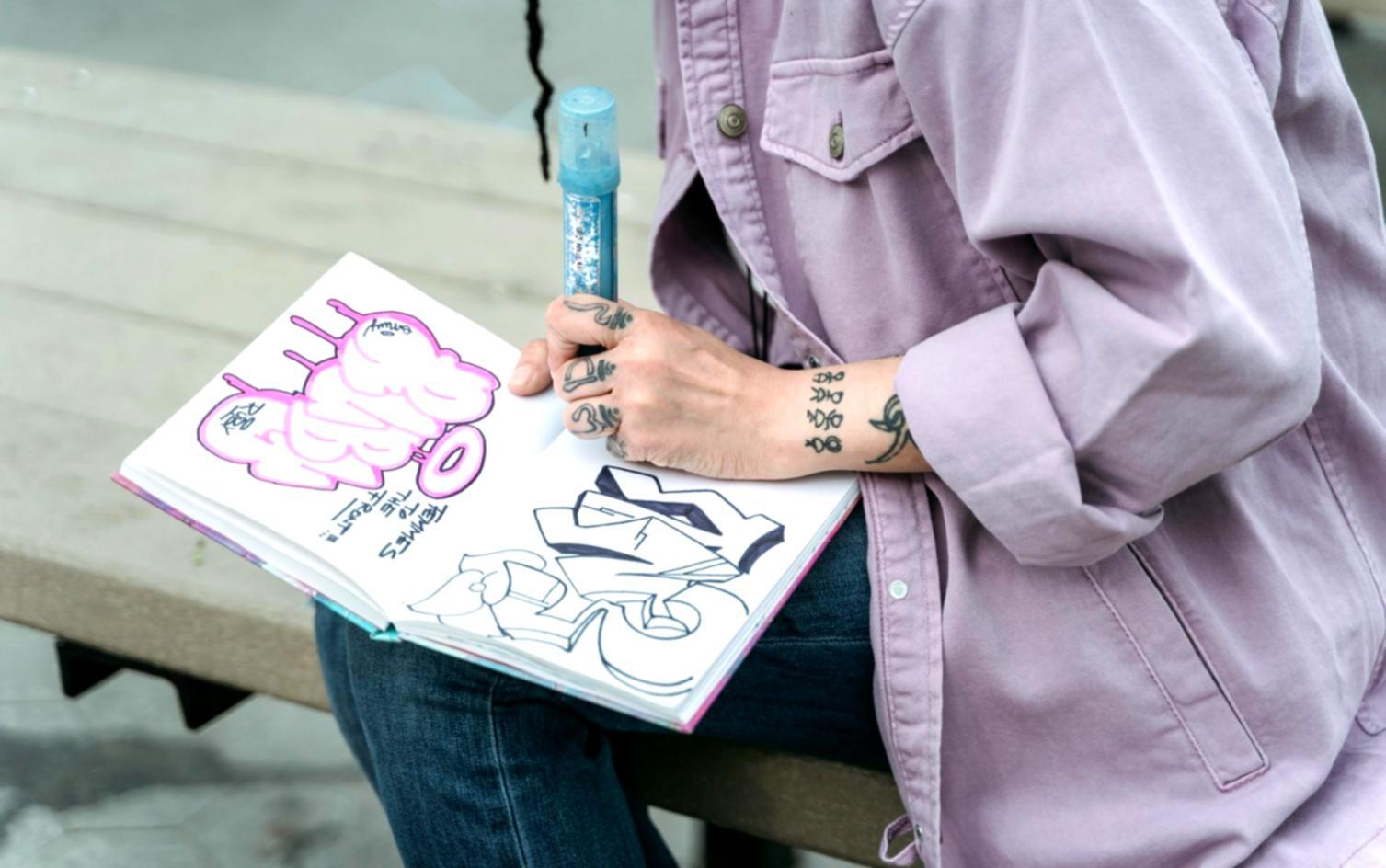 Primo piano di mani che disegnano con matita su carta